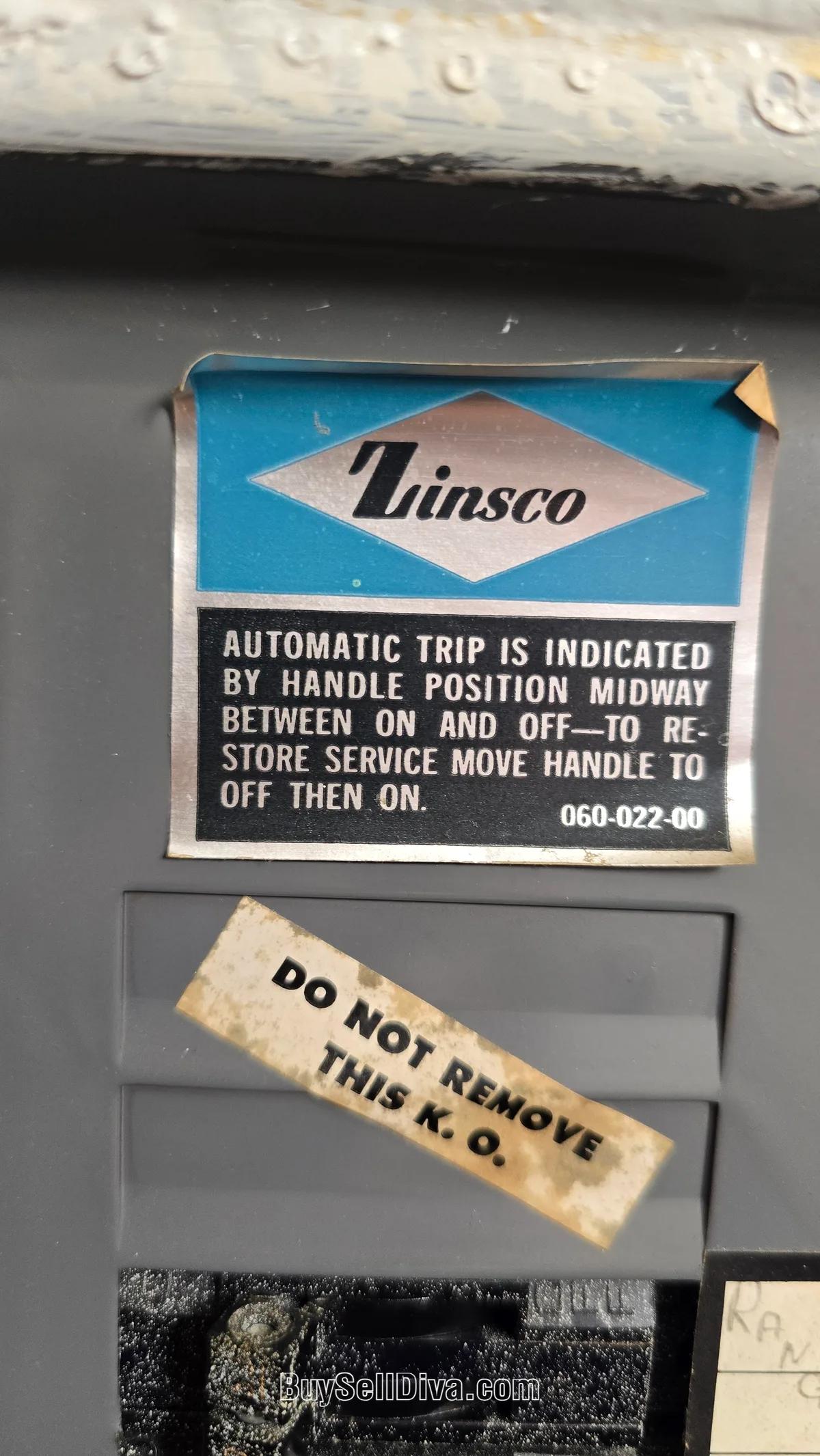 Close-up of the Zinsco diamond logo label on an electrical panel door, one of the fastest ways to identify a Zinsco panel