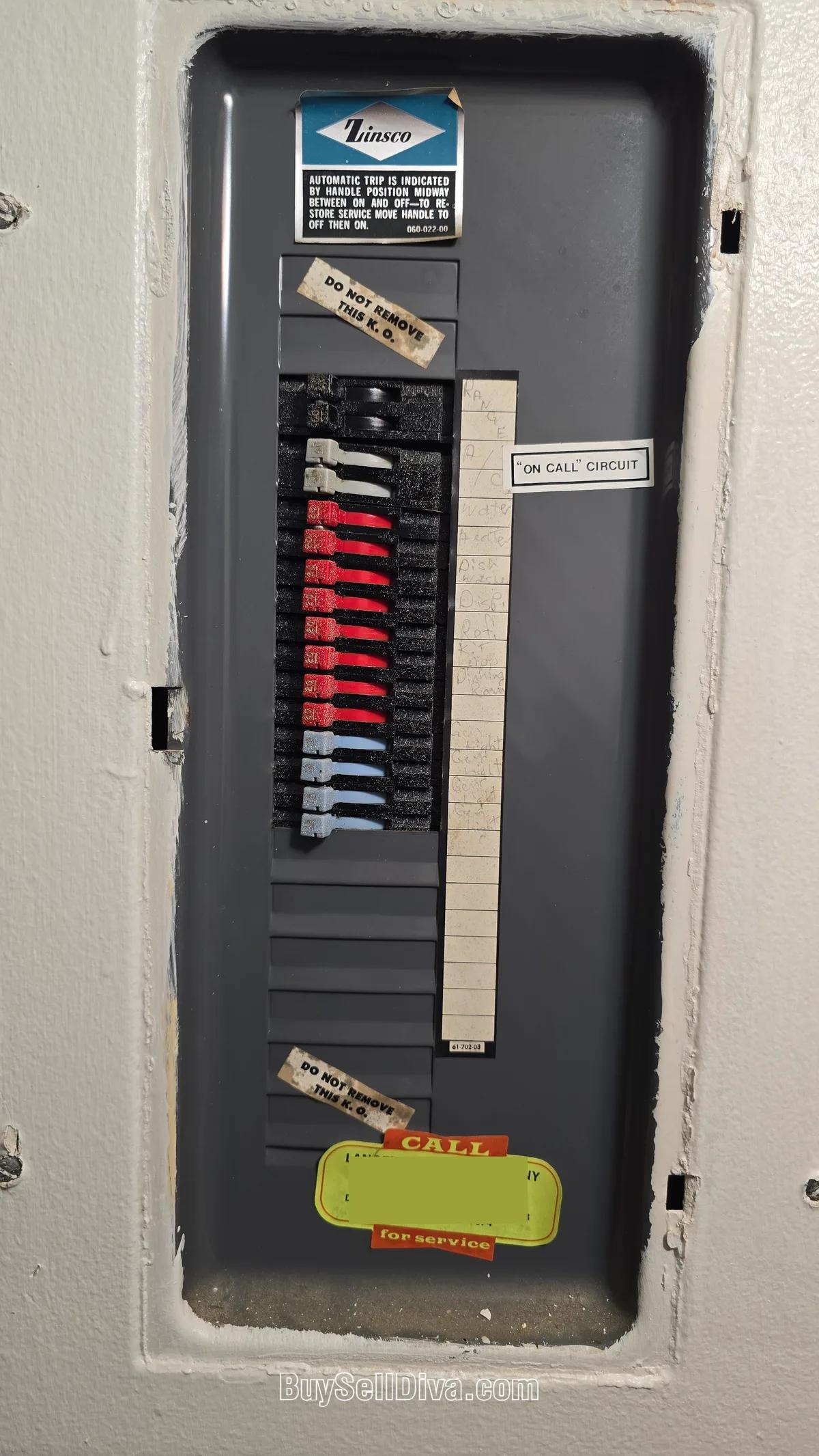 What a Zinsco electrical panel looks like: an open Zinsco panel in a South Florida home showing the Zinsco label and thin breakers with red and blue colored toggles, a documented fire-hazard panel