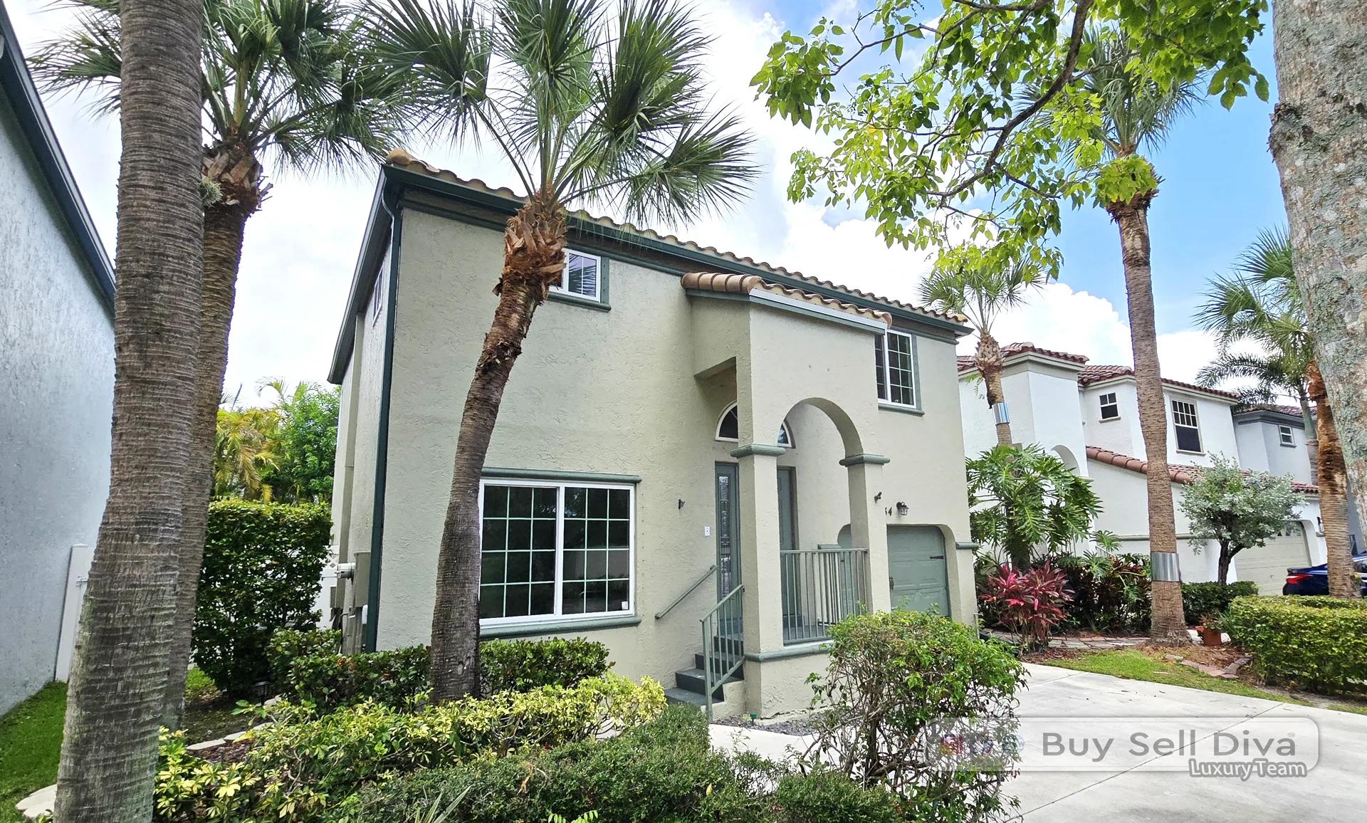 Front exterior of a two-story single-family home with barrel tile roof and palm trees at 134 NW 117th Avenue in Coral Springs, Florida