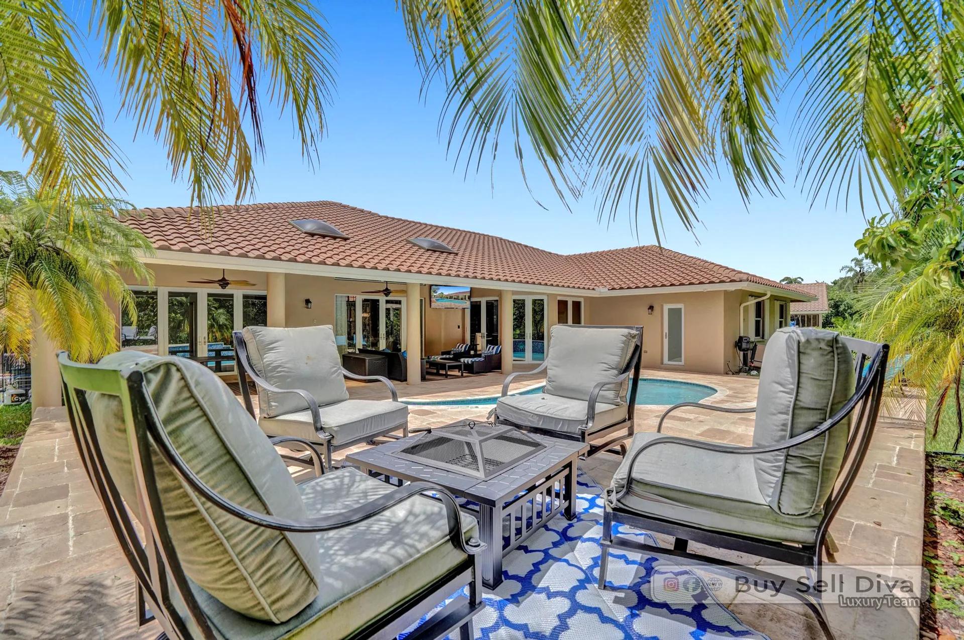 Fire pit with cushioned seating on the paver patio in the Weston Florida backyard