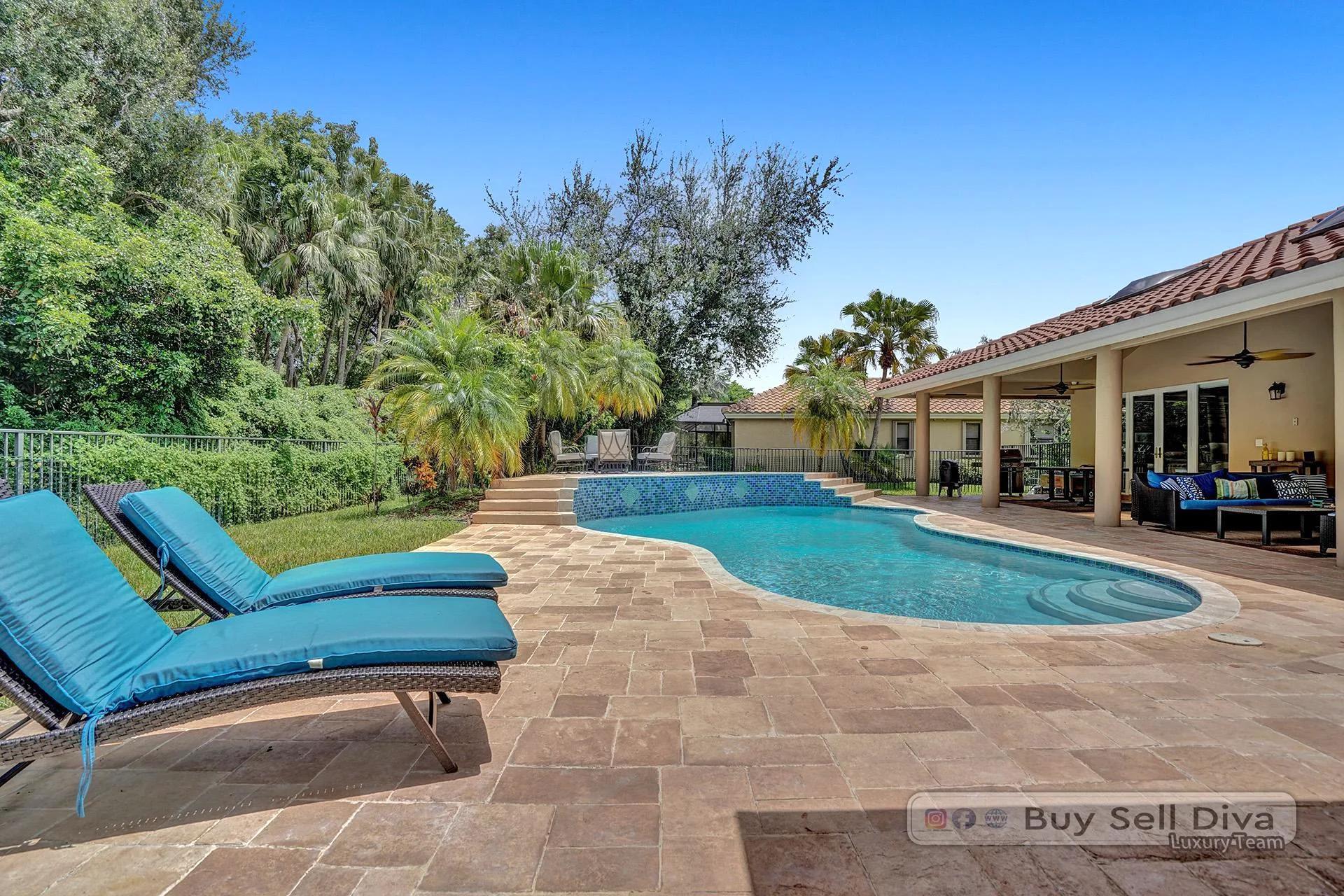 Backyard pool and patio with lush privacy landscaping at a Weston Florida home.