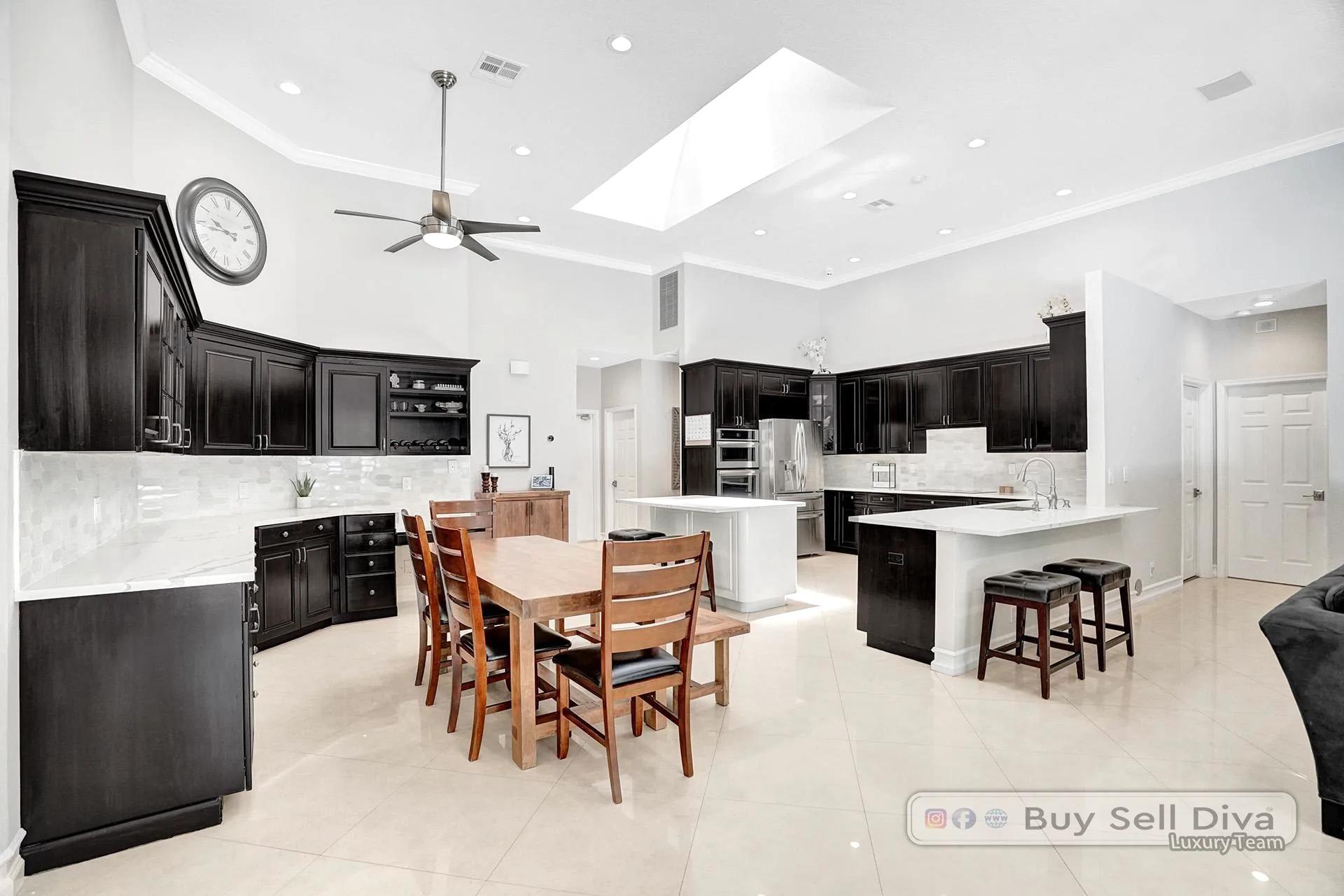 Large chef kitchen with skylight, double oven, and quartz counters in a Weston Florida home.