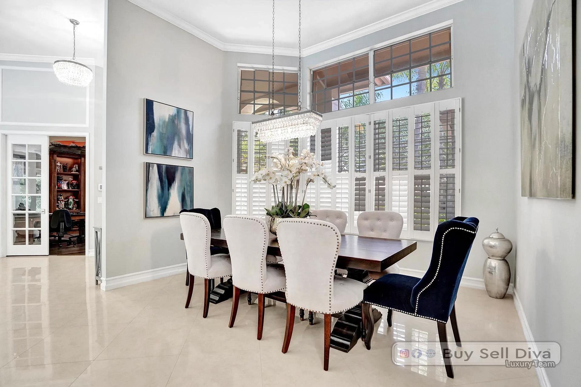 Staged dining room with tall windows and crown molding in a Weston Florida home.