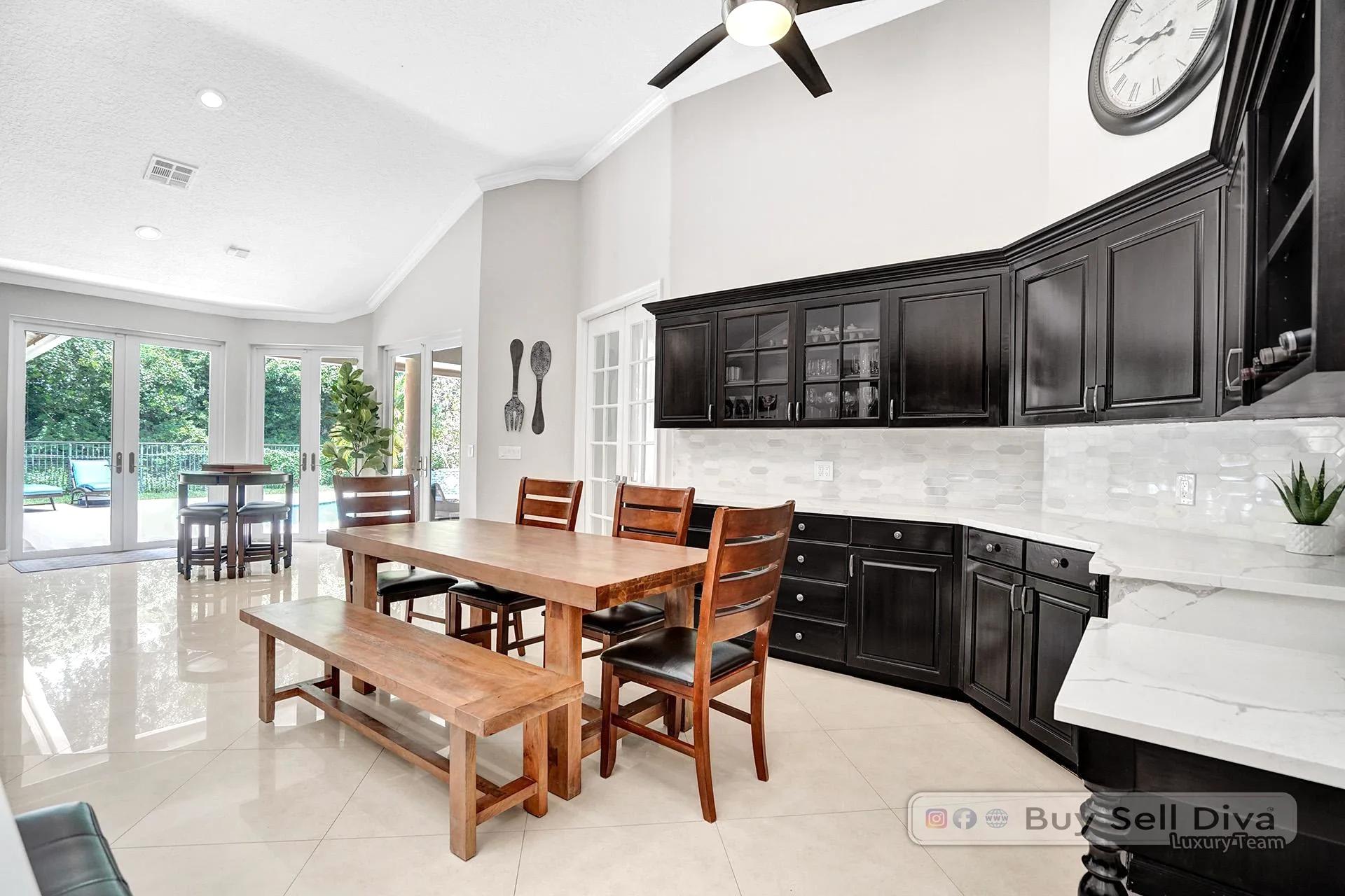 Eat-in kitchen with backyard pool view through French doors in a Weston Florida home.