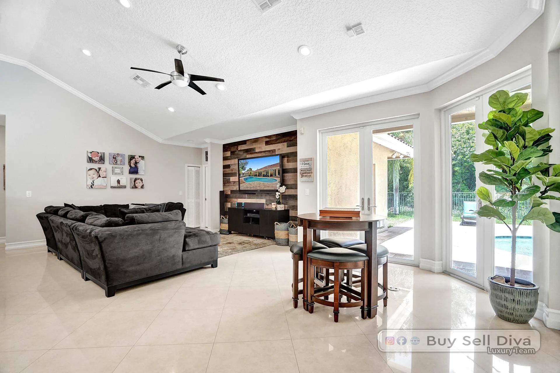 Family room with vaulted ceiling and pool view in a Weston Florida home.