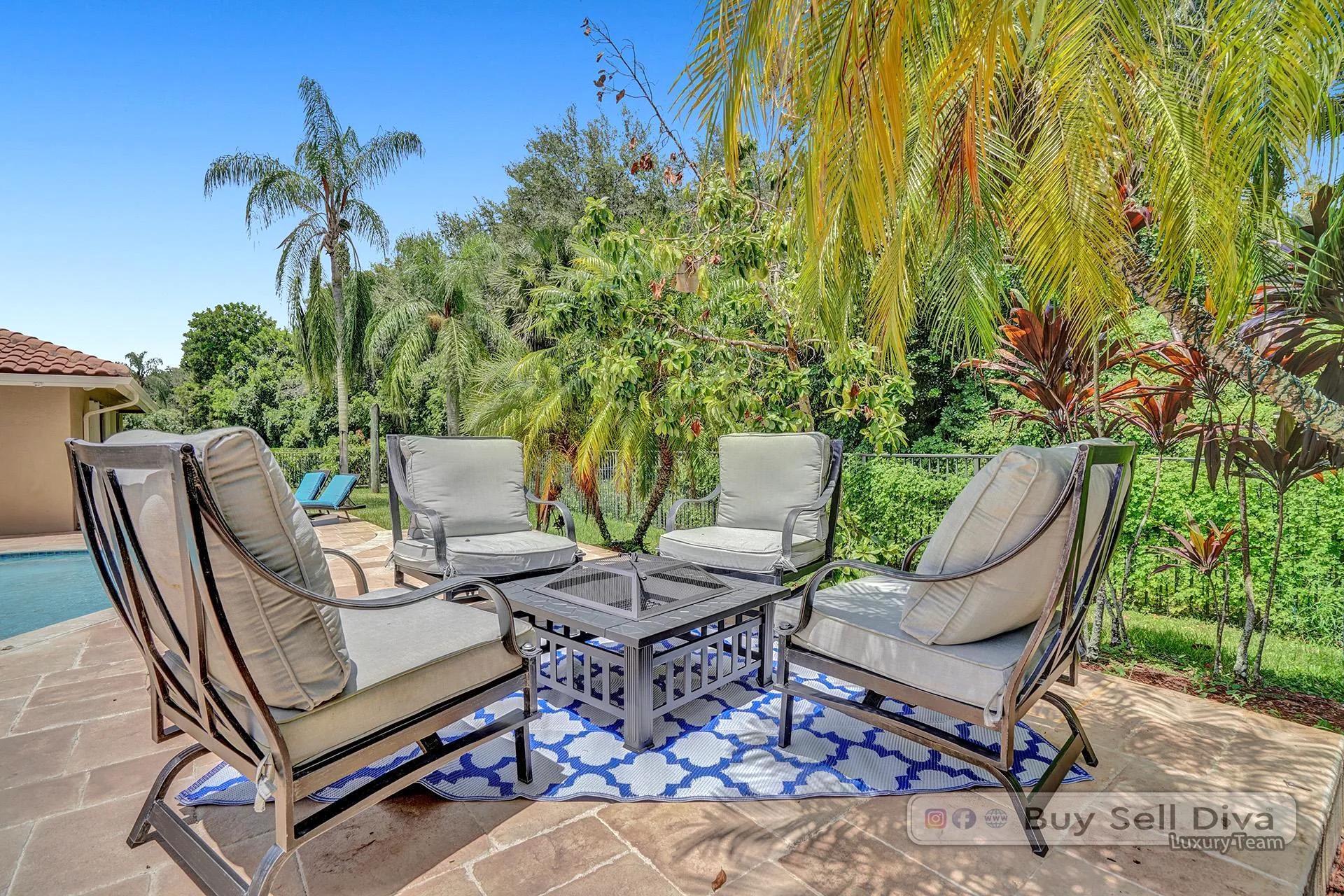 Fire pit seating area tucked into a tropical garden at a Weston Florida home.