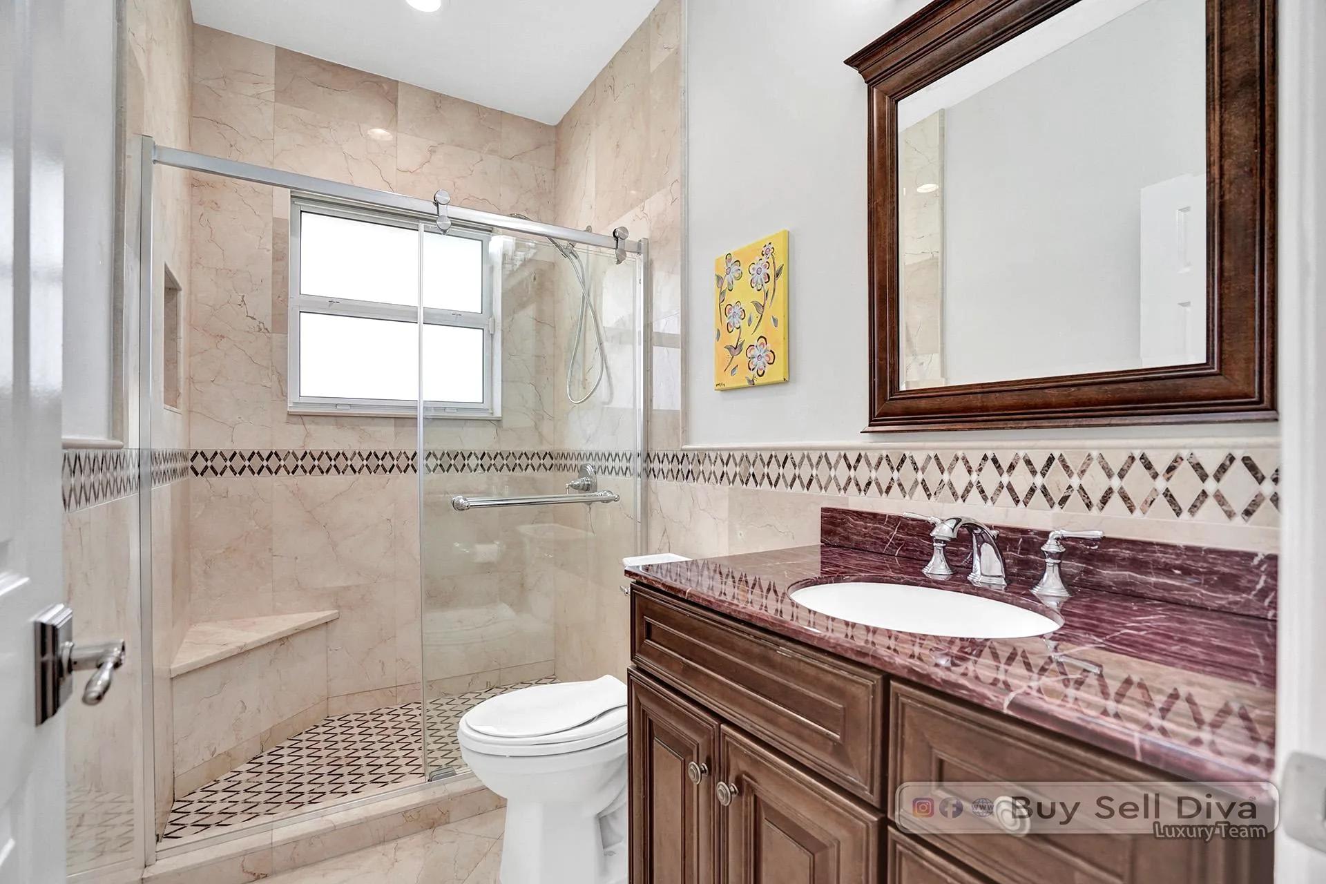 Remodeled guest bathroom with walk-in glass shower in a Weston Florida home.