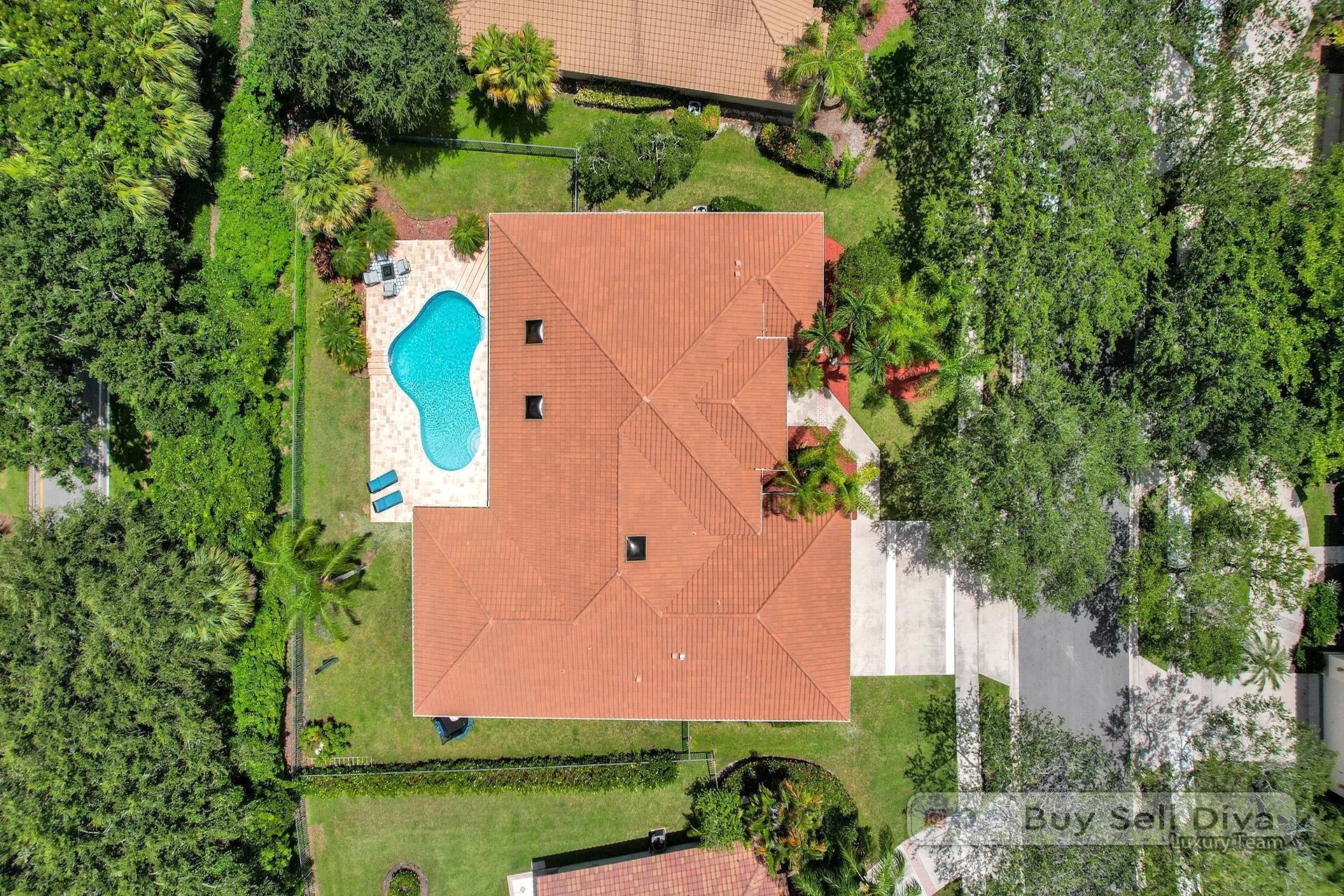 Overhead drone view of a Weston Florida home showing barrel tile roof and backyard pool.
