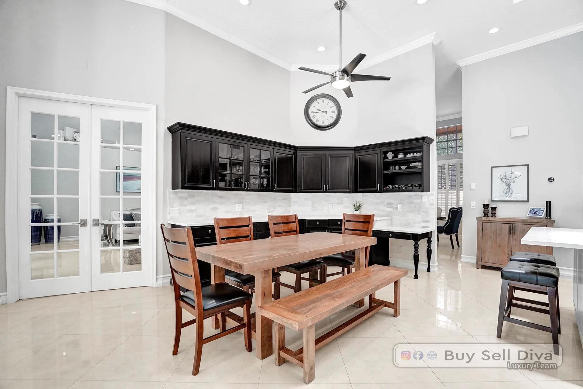 Kitchen dining space with French doors and dark wood cabinetry in a Weston Florida home.