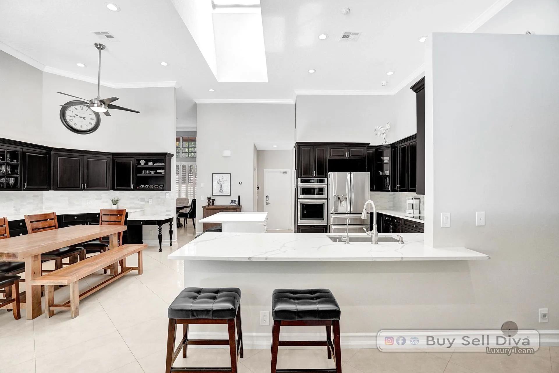 Chef kitchen with white quartz island and espresso cabinets in a Weston Florida home.