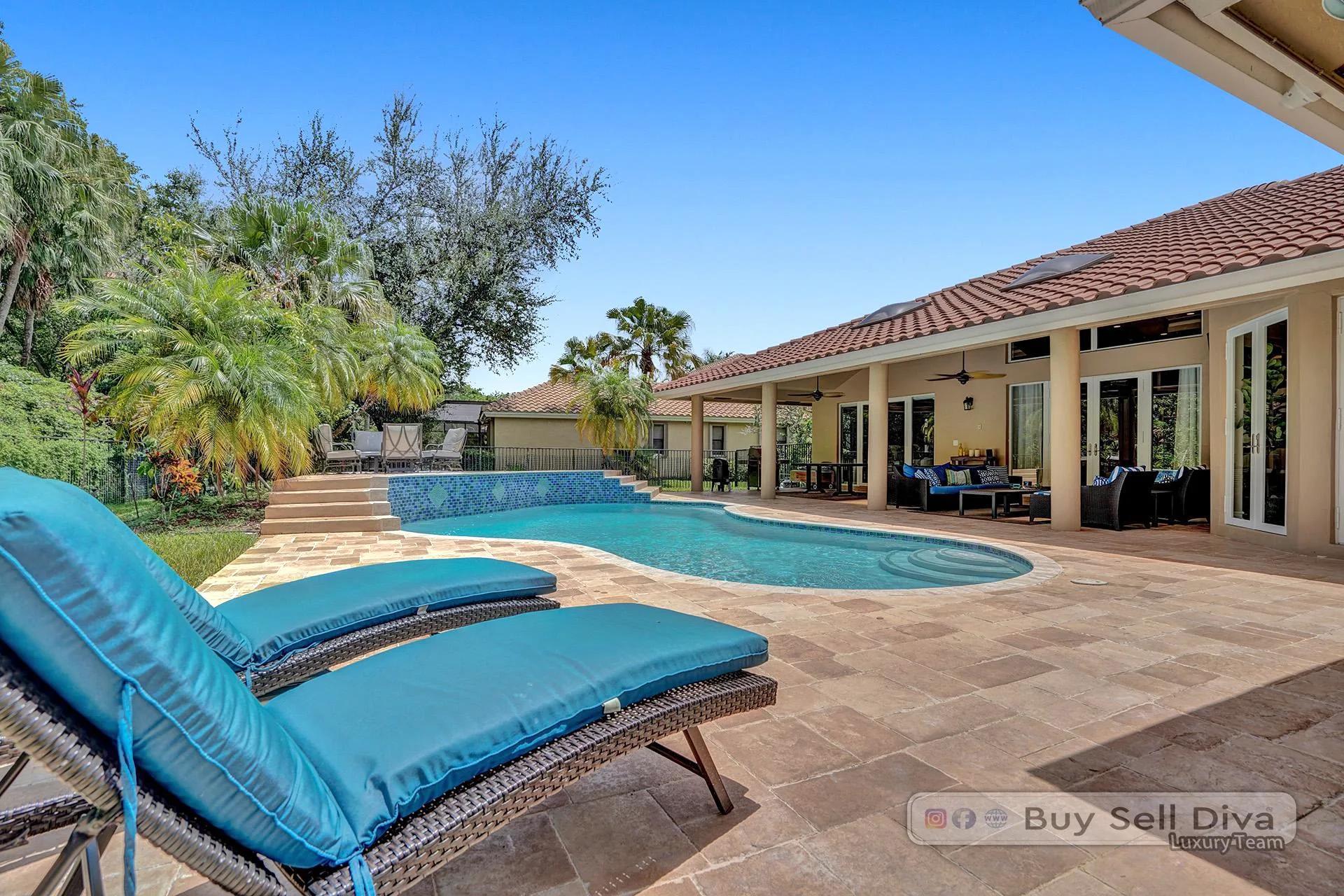 Rear exterior of a Weston Florida home with oversized pool and covered patio.