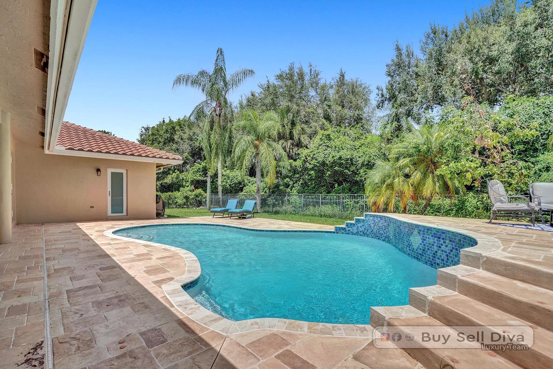 Backyard pool surrounded by tropical landscaping at a Weston Florida home.