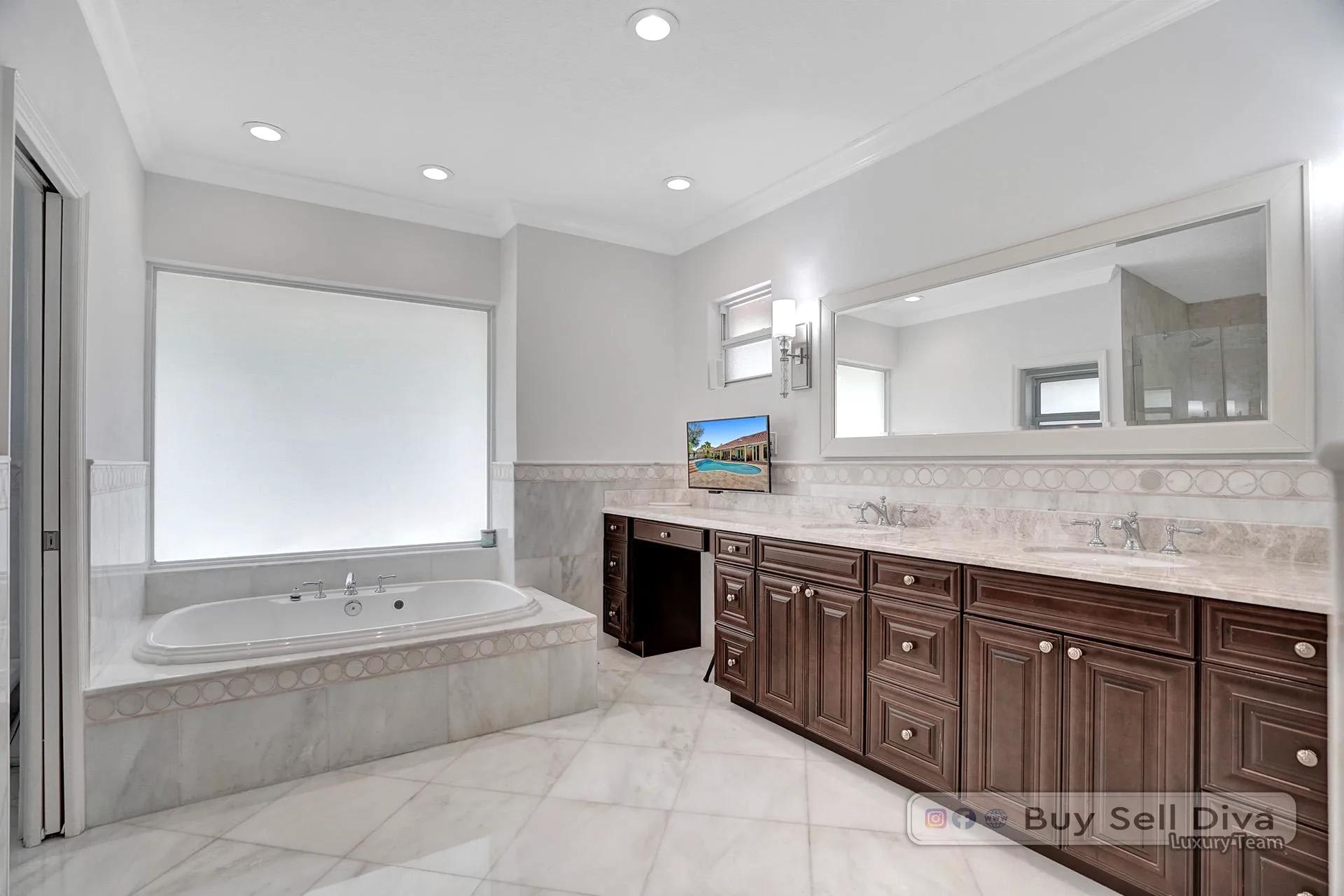Primary bathroom with double vanities and marble counters in a Weston Florida home.