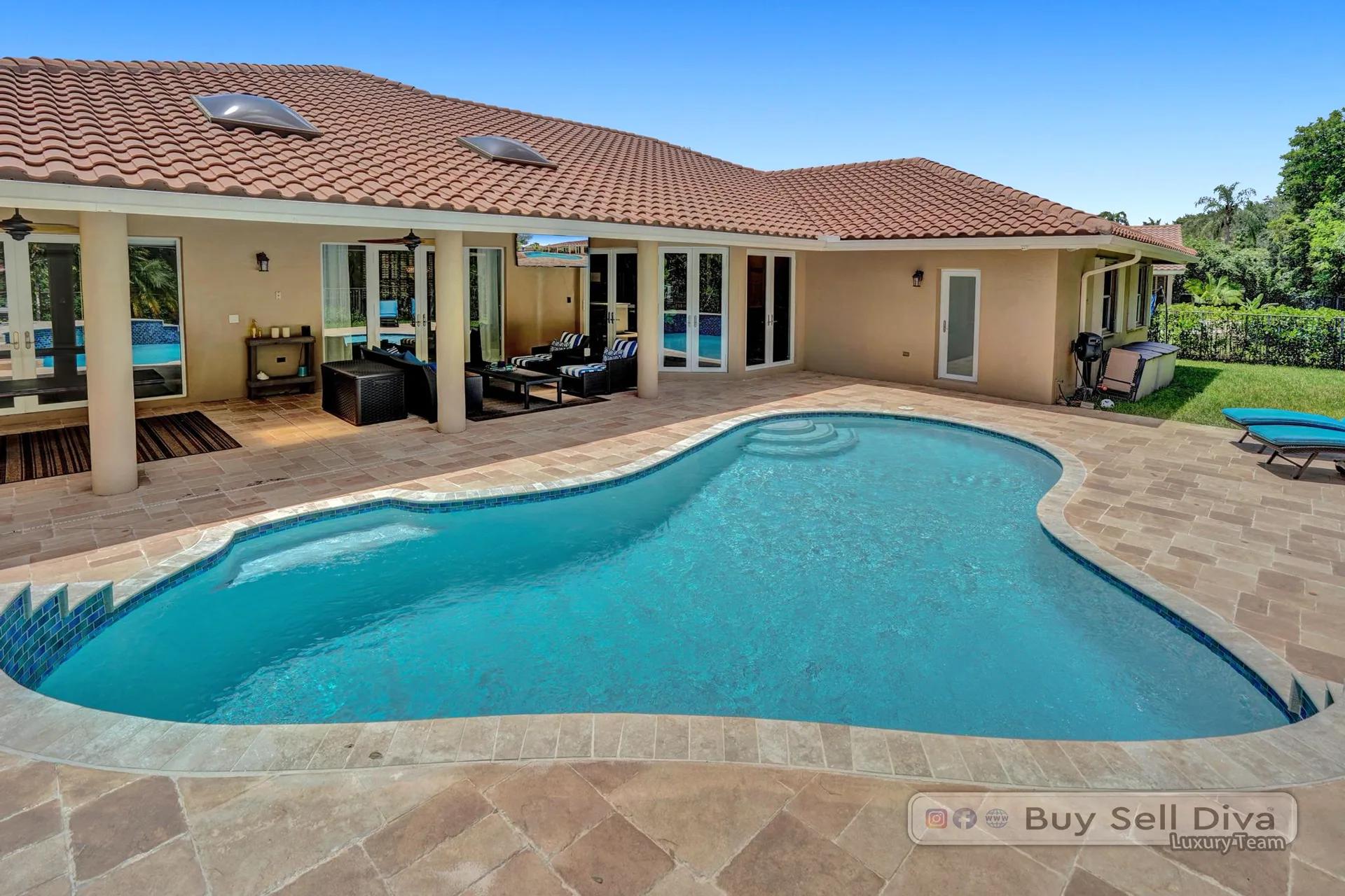 Resort-style backyard pool with tropical borders at a Weston Florida home.