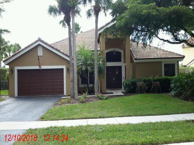 Whittier Oaks Parkland FL home exterior with mature landscaping and circular driveway