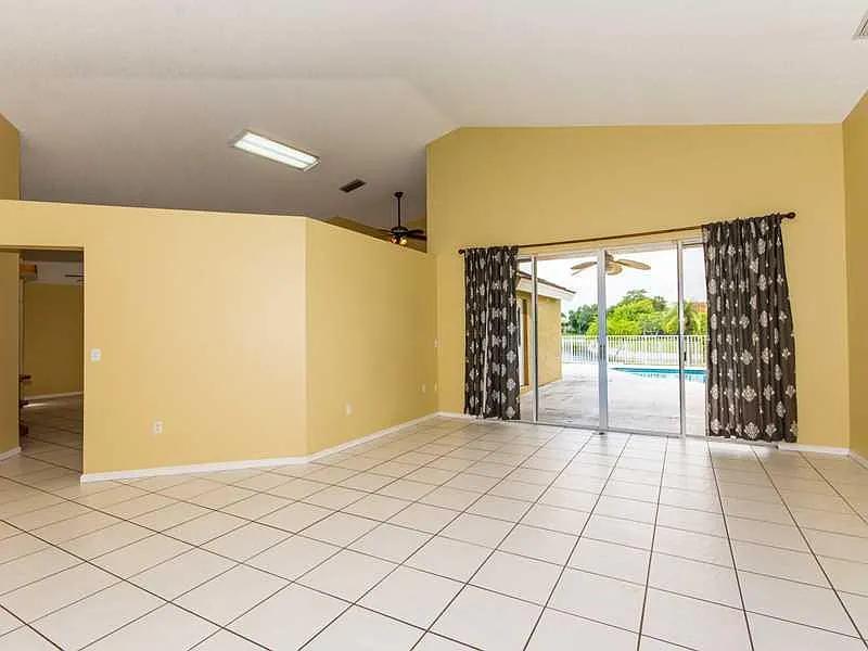 Full outdoor kitchen and covered patio overlooking the lake at 7565 NW 75th Drive Parkland FL