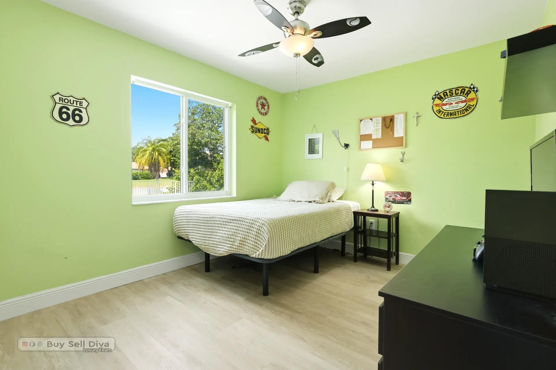 Fourth bedroom with ceiling fan and lake view window