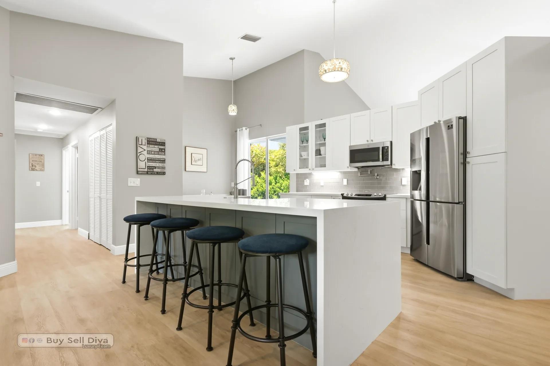 Remodeled kitchen with island seating, pendant lighting, and pantry wall
