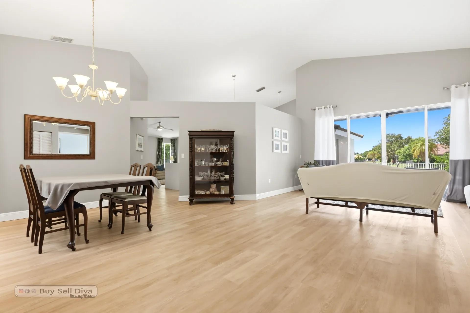 Formal living room with vaulted ceiling and wall of sliders to the pool