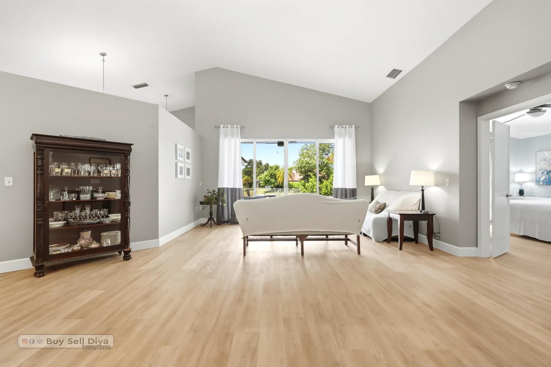 Open formal living and dining area with light wood-look flooring