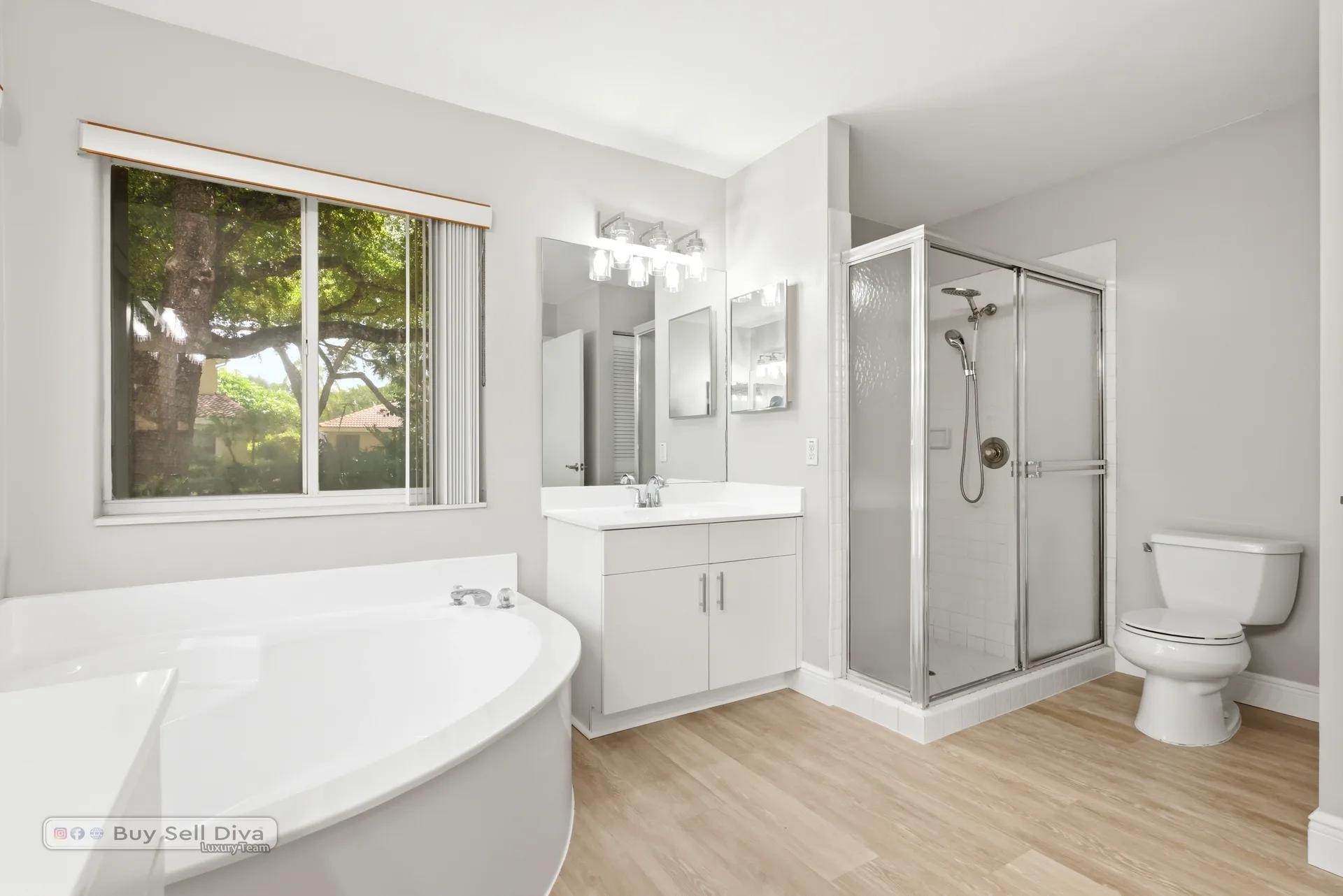 Primary bathroom with soaking tub, glass shower, and garden window