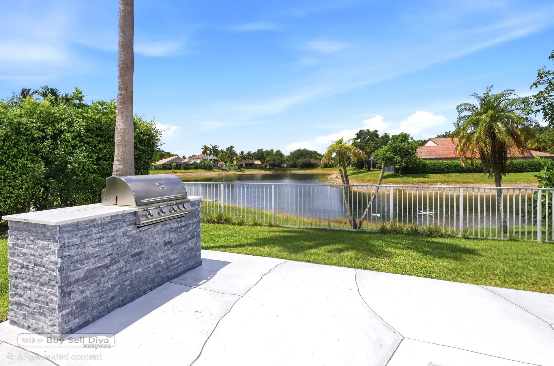 Built-in stone outdoor kitchen with grill overlooking the lake