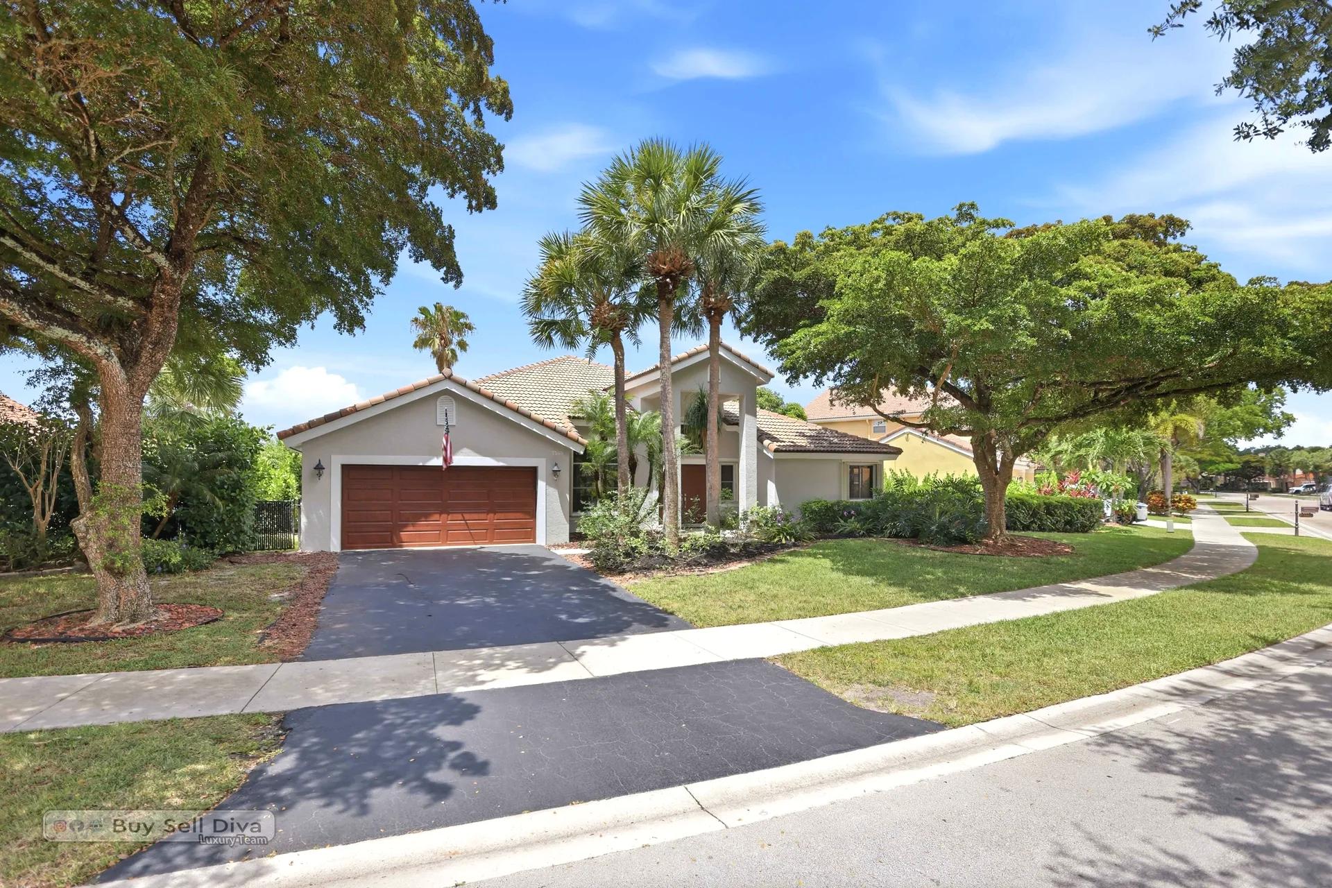Driveway and two-car garage with lush corner-lot landscaping