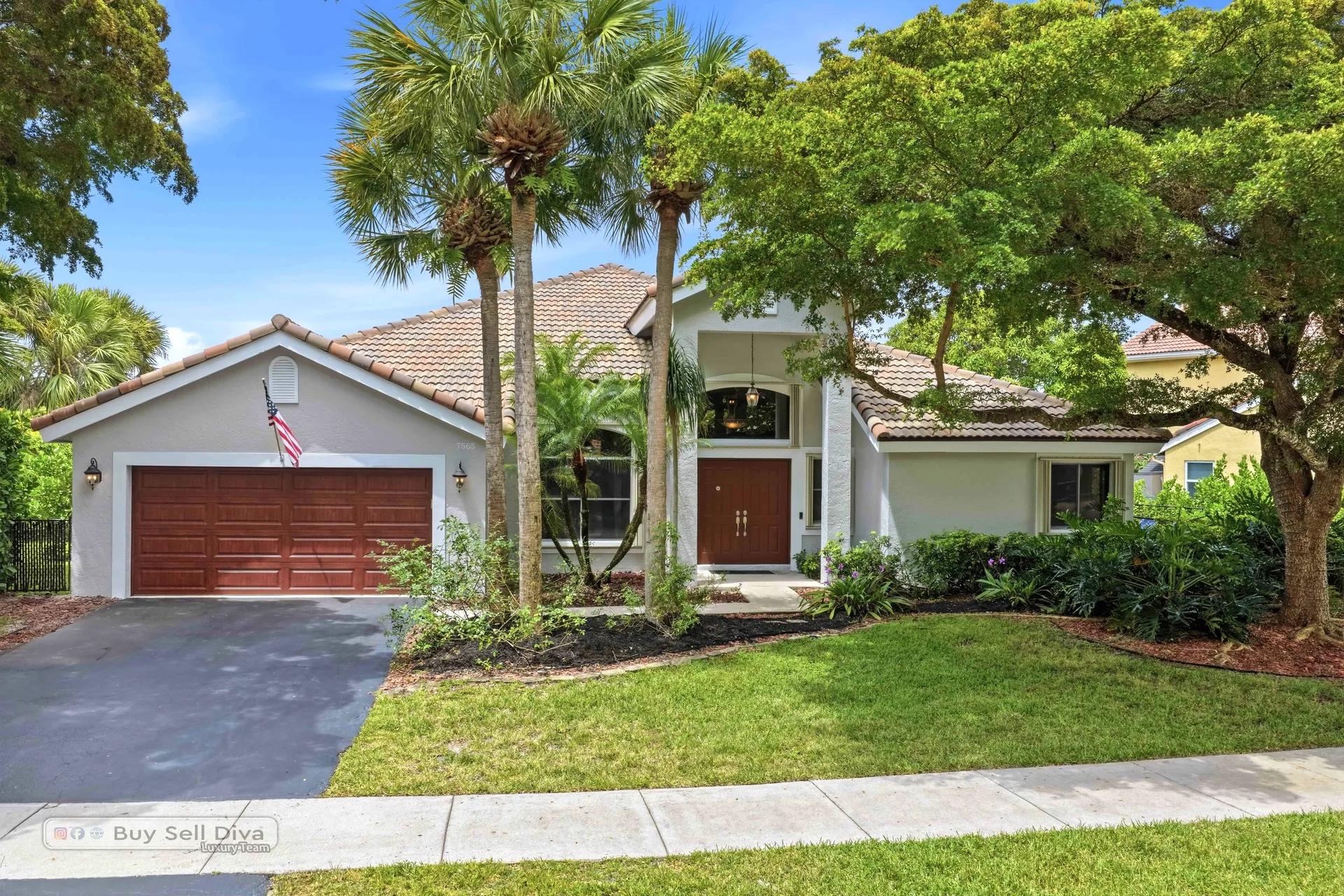 Front exterior of 7565 NW 75th Drive, a lakefront pool home in guard-gated Whittier Oaks at Parkland Florida
