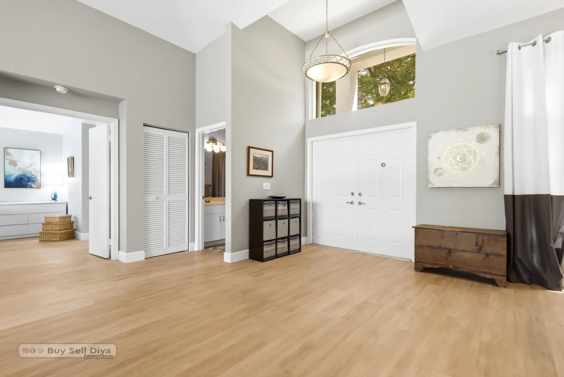 Double-door entry foyer with soaring ceiling and transom window