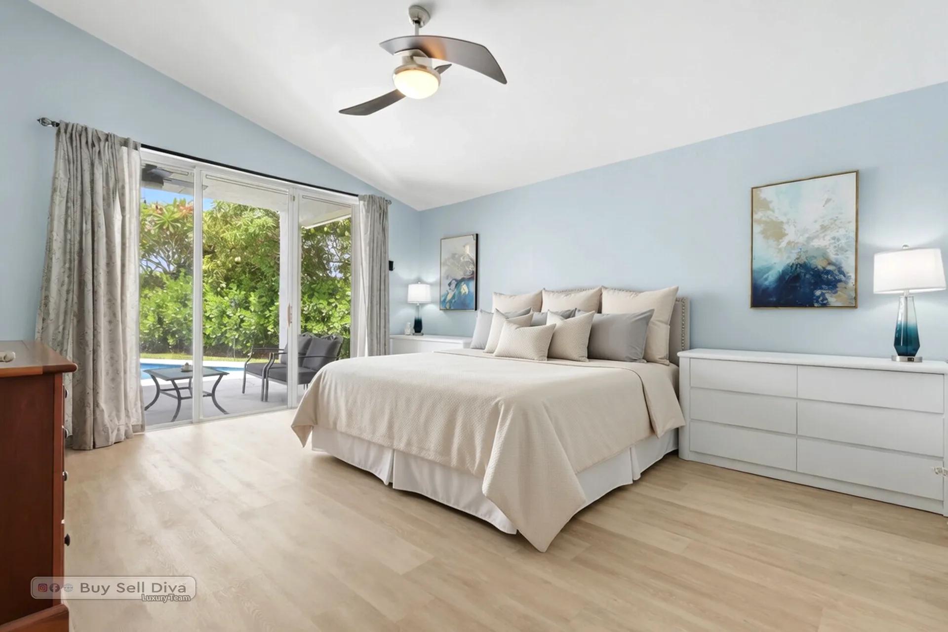Primary bedroom with pool and patio views through glass doors