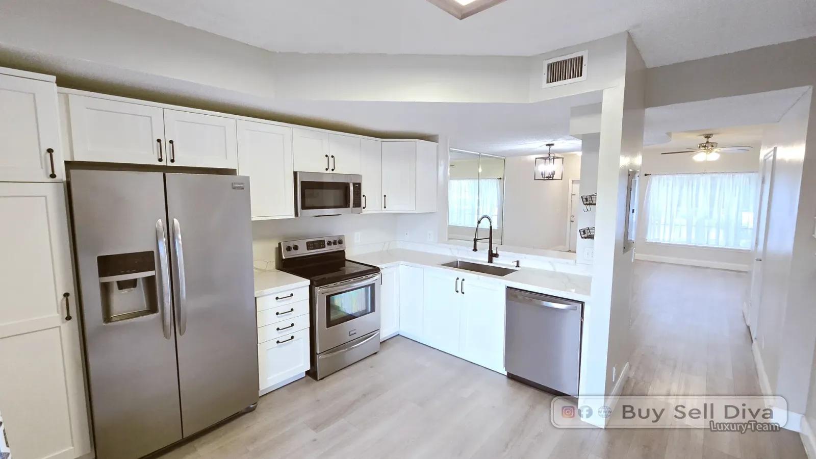 Renovated white shaker kitchen with stainless appliances in the Coral Reef Club townhome