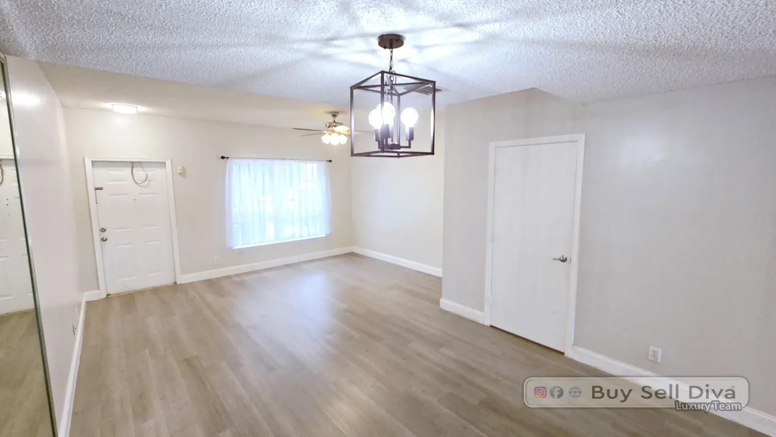 Living room of the Coral Springs FL townhome with lantern chandelier and light plank floors
