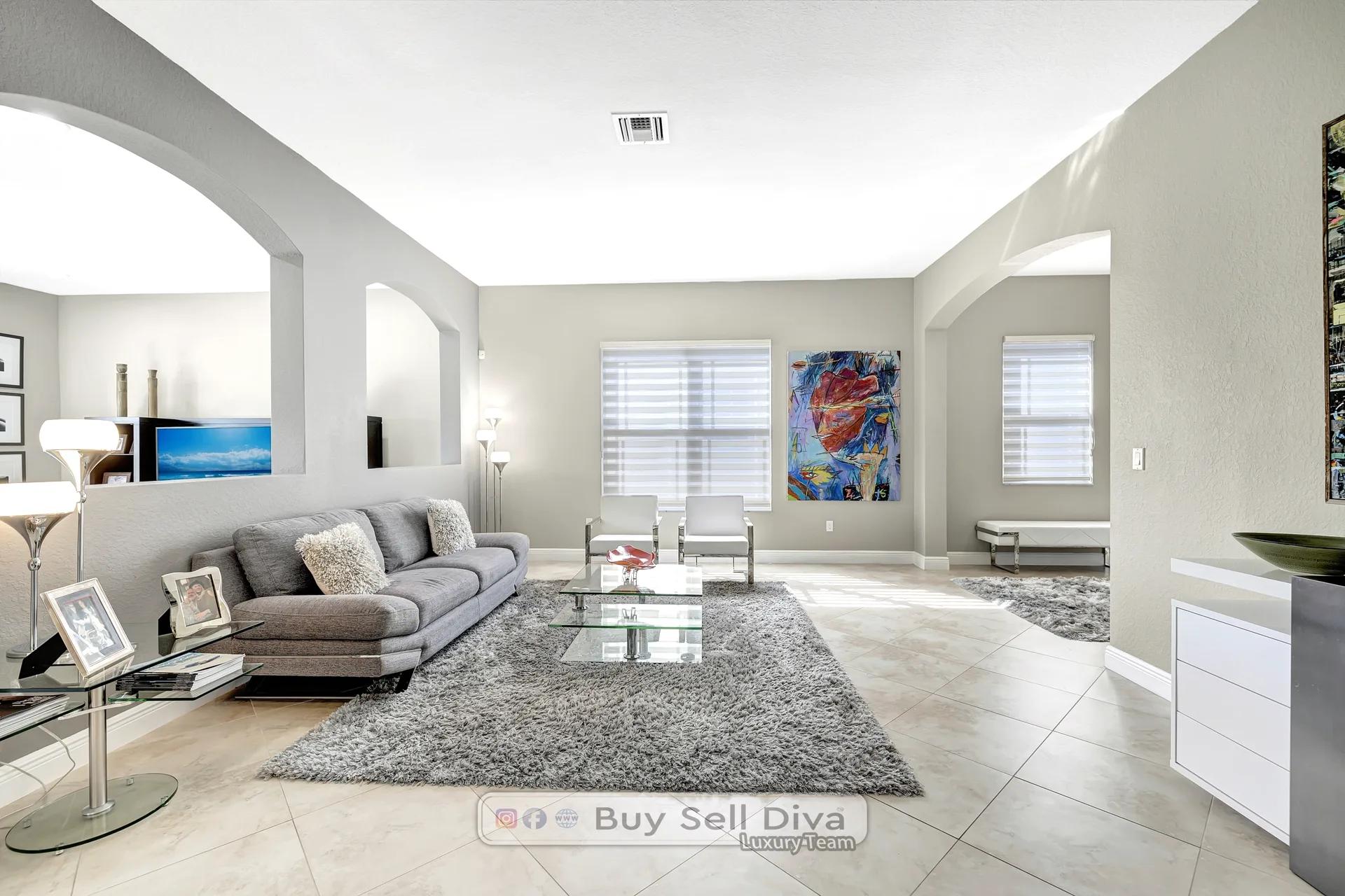 Bright living room with arched entries and tile floors inside the Parkland Florida home