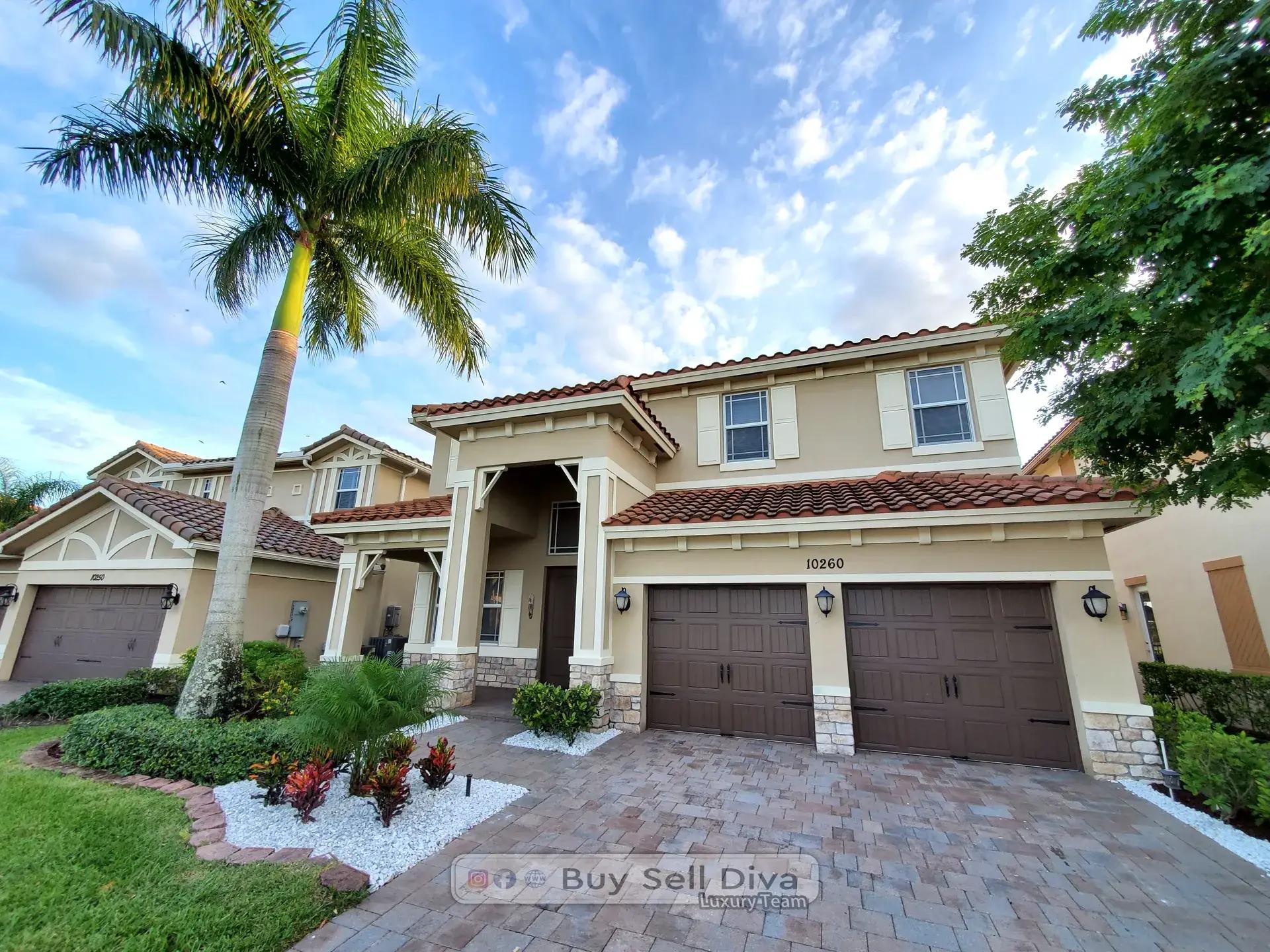 Street view of the two-story MiraLago home in Parkland Florida framed by a royal palm