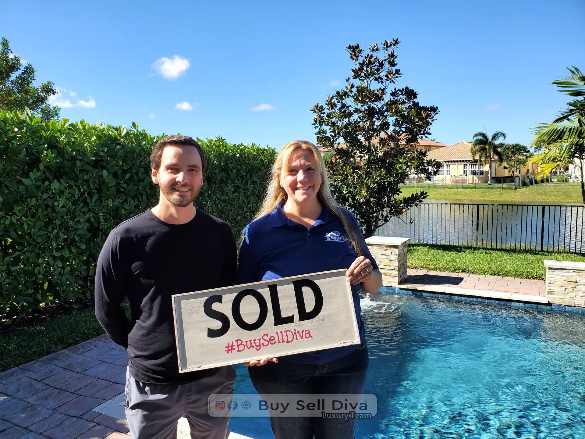 Beth McKeone of Buy Sell Diva celebrating a closed sale with a SOLD sign beside the water in Parkland Florida