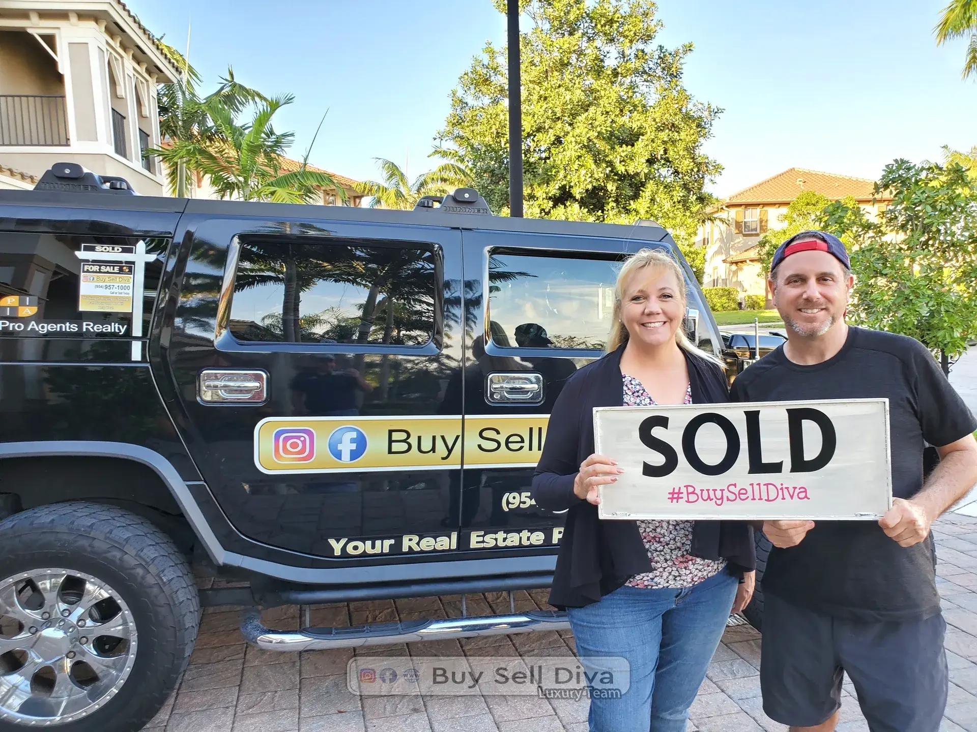 Clients holding a SOLD sign in front of the Buy Sell Diva Hummer after closing on their MiraLago home in Parkland Florida