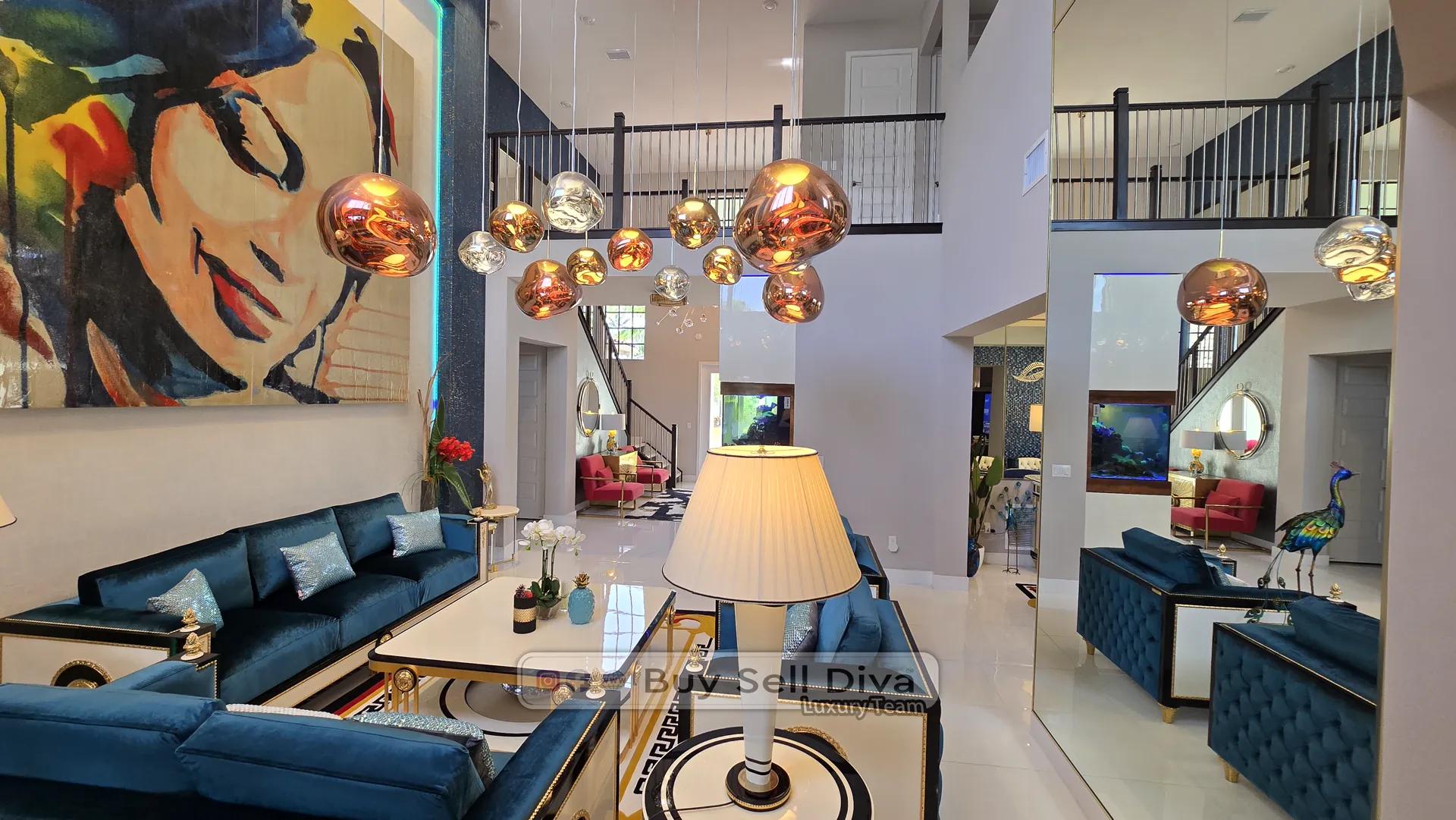 Parkland FL estate home: two-story living room with cluster copper globe chandelier and blue velvet sofas