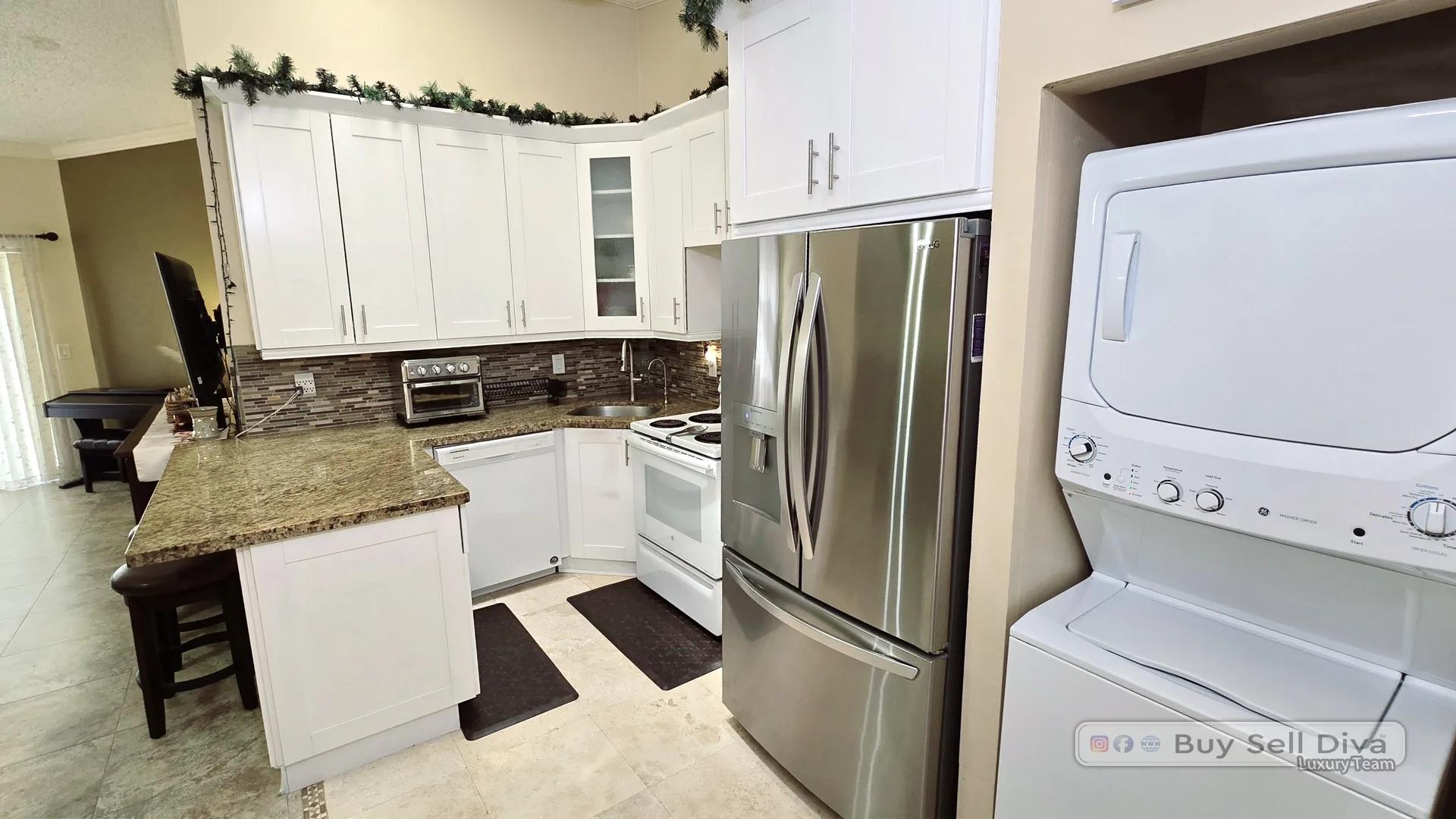 Townhouse kitchen with granite peninsula and an in-unit stacked washer and dryer in Deerfield Beach
