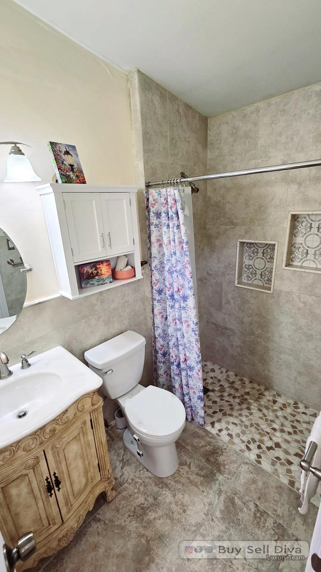 Second remodeled bathroom with a walk-in tile shower and vanity in a Deerfield Beach rental townhouse