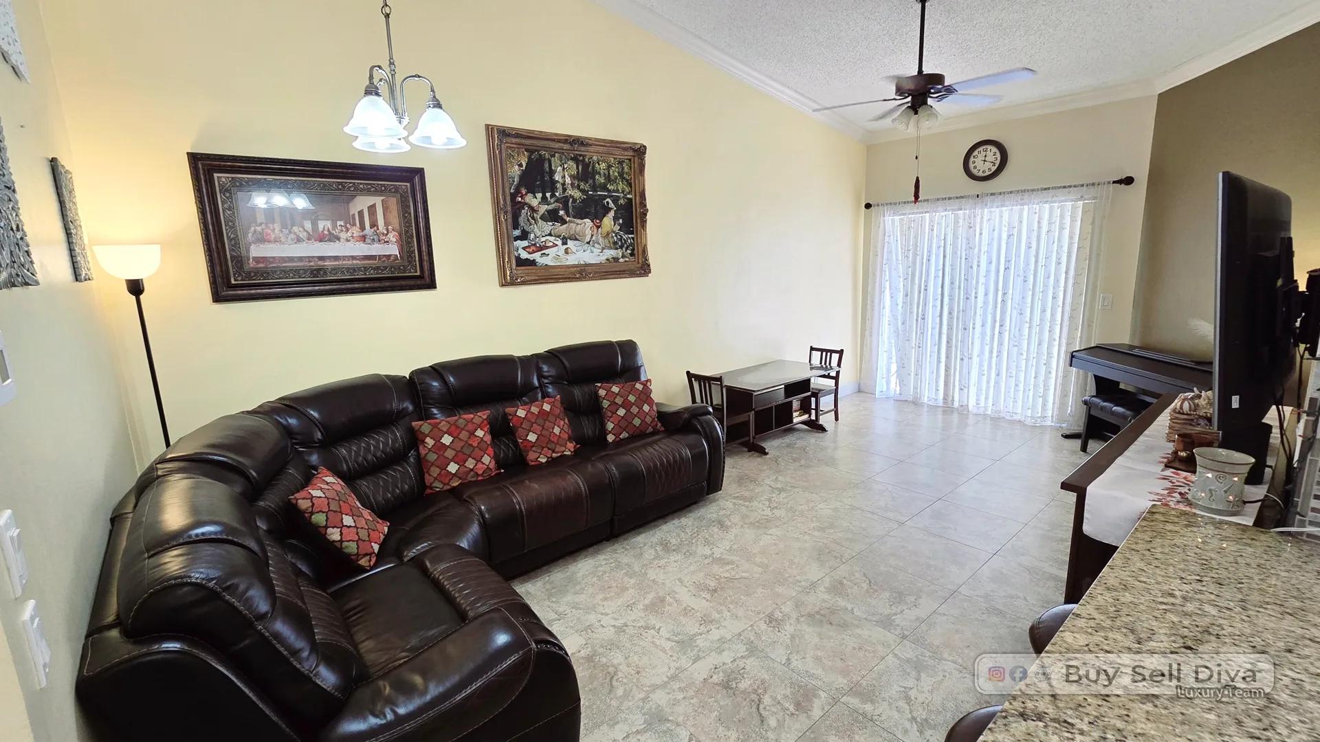 Living room with sliding glass doors opening to a private patio in a Deerfield Beach townhouse rental