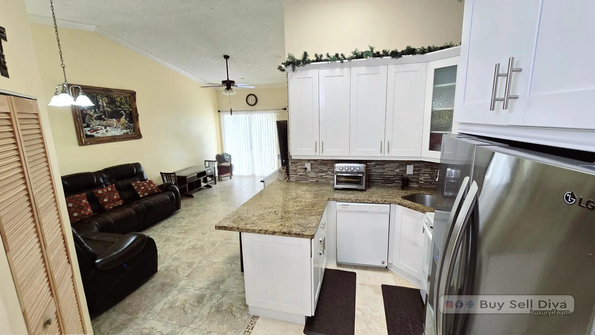 Open kitchen and living area with vaulted ceiling in a Broward County townhouse for rent in Deerfield Beach