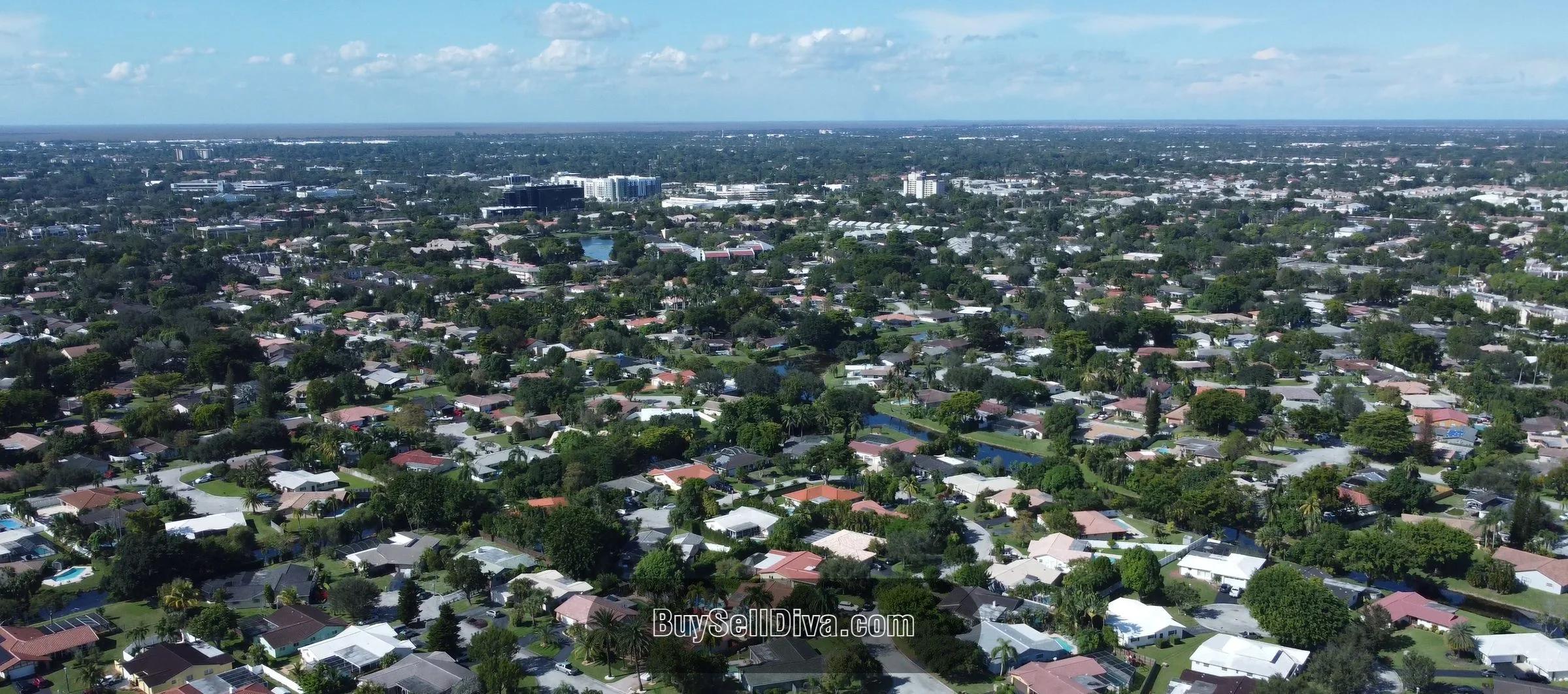 Aerial view of Forest Hills in Coral Springs, FL: single-family rooftops, mature tree canopy, and neighborhood lakes in Broward County